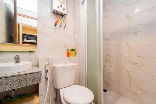 a bathroom with a toilet and a sink at RedLiving Apartemen Grand Kamala Lagoon - Icha Rooms Tower Barclay South with Netflix in Bekasi