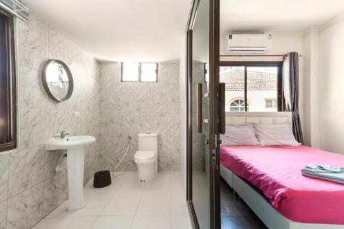 1 dormitorio con cama, lavabo y aseo en wonderland2 village KTV pool villa en Pattaya North