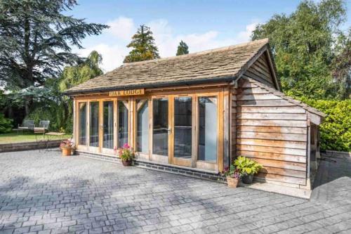 un pequeño edificio de madera con muchas ventanas en Poplars Cottage Luxury Detached Home With Outbuildings - Nr Bristol & Bath, 