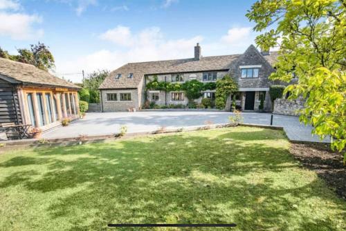 una vista exterior de una casa con un gran patio en Poplars Cottage Luxury Detached Home With Outbuildings - Nr Bristol & Bath, 