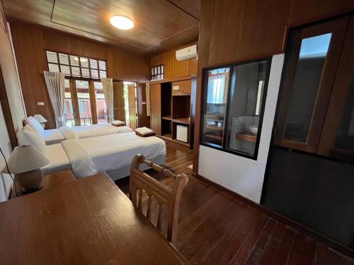 1 dormitorio con cama, mesa y TV en Utopia Resort, en Lamai