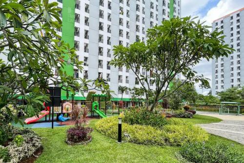 a park with a playground in front of a building at RedLiving Apartemen Green Lake View Ciputat - Syafa Property Tower E in Pondokcabe Hilir