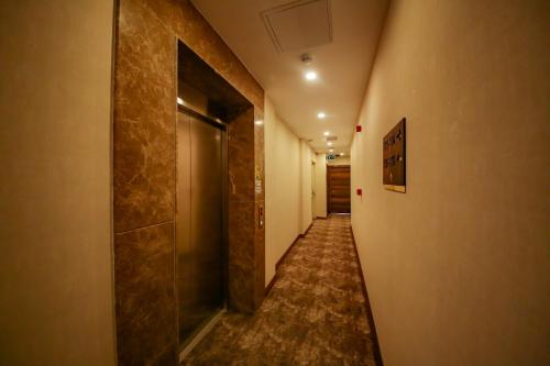 a hallway with a long corridor with a door and a hallwayngth at ALKAN PALACE HOTEL in Keşan