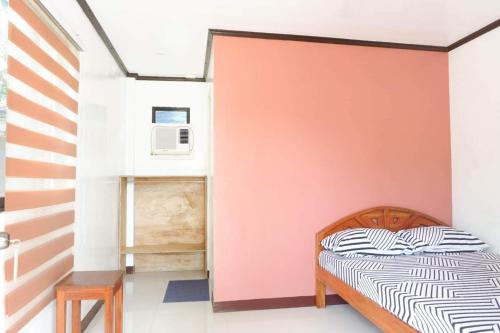 a bedroom with a bed and a red wall at LMIRAMARS Tourist Inn in Itaytay