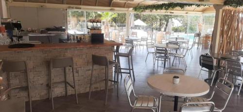 een bar met stoelen en tafels in een restaurant bij Résidence hôtelière les hameaux de saint cyprien appartement 35 M2 1 chambre in Lecci
