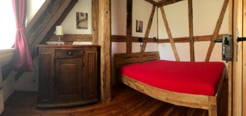 um quarto com uma cama com um cobertor vermelho em Ferienwohnung Mainidylle em Winterhausen