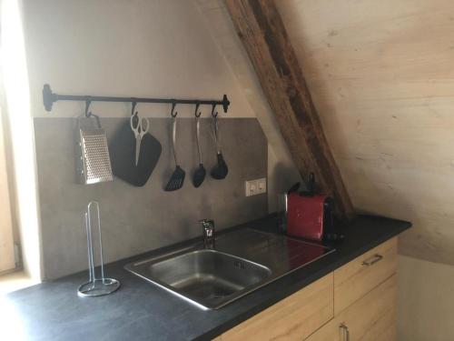 um balcão de cozinha com um lavatório e utensílios em Ferienwohnung Mainidylle em Winterhausen