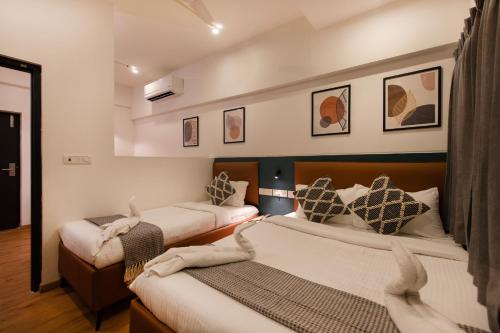 two beds in a hotel room with two beds at Convastay Prestige- Near Apollo Hospital & US Consulate in Chennai