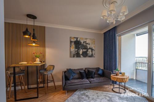 ein Wohnzimmer mit einem Sofa und einem Tisch in der Unterkunft Apartament Panorama in Olsztyn