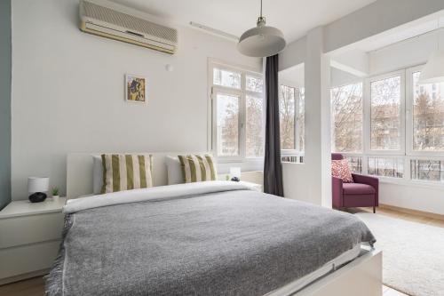 een witte slaapkamer met een groot bed en ramen bij Specious and Stylish Apartment Near Bagdat Street with Excellent Location in Kadikoy in Istanbul