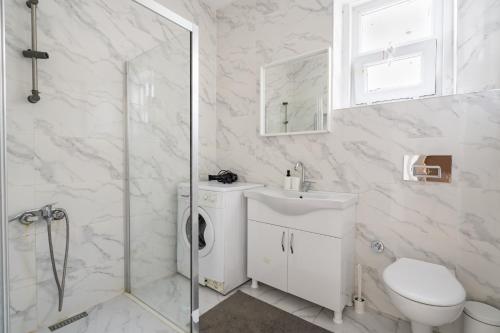 een witte badkamer met een toilet en een douche bij Specious and Stylish Apartment Near Bagdat Street with Excellent Location in Kadikoy in Istanbul