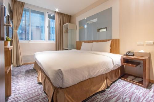 a hotel room with a large bed and a window at Muzik Hotel - Ximending Xining Branch in Taipei