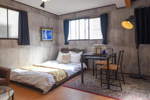 a bedroom with two beds and a table and a desk at Comfy Stay MR1 & MR2 in Nara