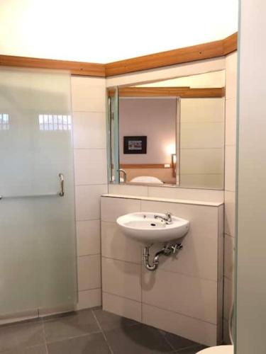 a bathroom with a sink and a mirror at Citrus-House com Hotel in Bogor