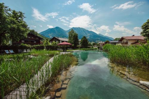 a river in a village with mountains in the background at Landhotel Lerch Plankenau in Sankt Johann im Pongau