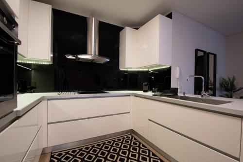 uma cozinha com armários brancos e um lavatório em Casa Artistico em Stavrákion