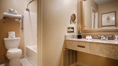 a bathroom with a toilet and a sink and a mirror at Best Western Plus Heritage Inn in Benicia