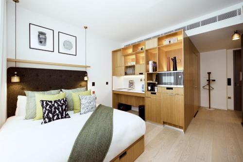 a bedroom with a large bed and a kitchen at Wilde Aparthotels London Covent Garden in London