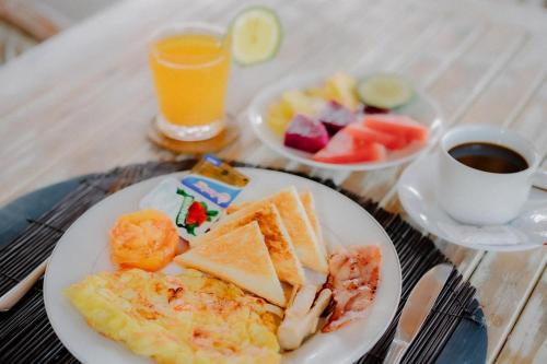 a plate of breakfast food and a cup of coffee at The Lavana Jhonny Kibung Villas Lembongan in Nusa Lembongan