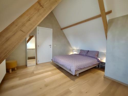 - une chambre mansardée avec un lit violet dans l'établissement Nachtegael Hoekhuis, knusse woning met prachtig vergezicht, à Kluisbergen