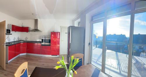 a kitchen with red cabinets and a large window at M & M Hotel in Oyten