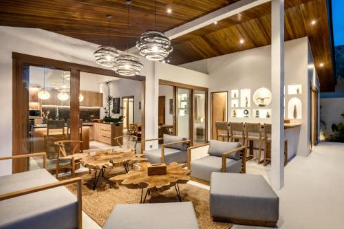 ein Wohnzimmer mit Tisch und Stühlen und eine Küche in der Unterkunft Villa Tchikobo by BaliSuperHost in Ubud
