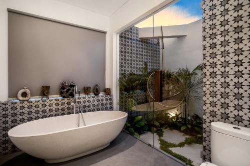 y baño con bañera blanca y ducha. en Villa Tchikobo by BaliSuperHost, en Ubud