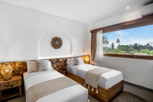 2 camas en una habitación con ventana en Villa Tchikobo by BaliSuperHost, en Ubud