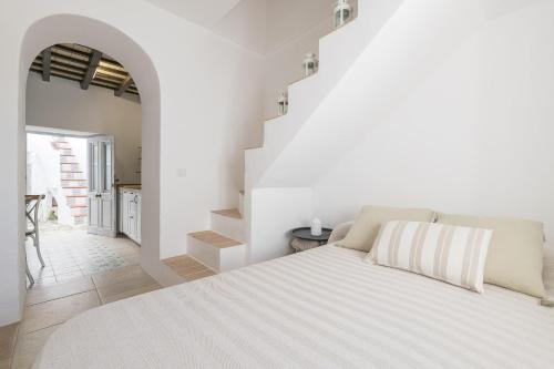 ベヘール・デ・ラ・フロンテーラにあるCasa Manuelaの白いベッドルーム(大型ベッド1台付)と階段