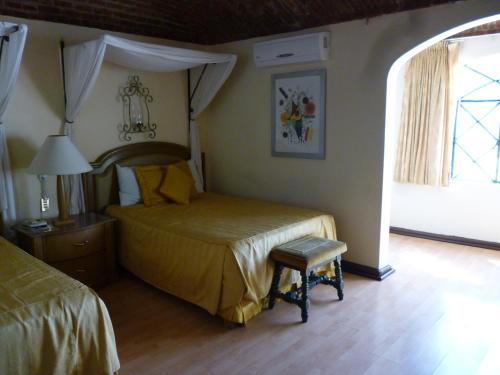 a bedroom with a bed and a chair and a window at Hotel Castillo de Santa Cecilia in Guanajuato