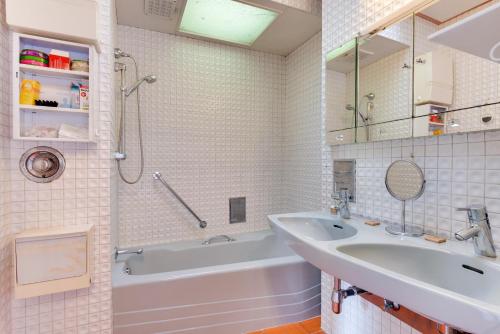 bagno con lavandino, vasca, lavandino e specchio di Expo Garden House a Wemmel