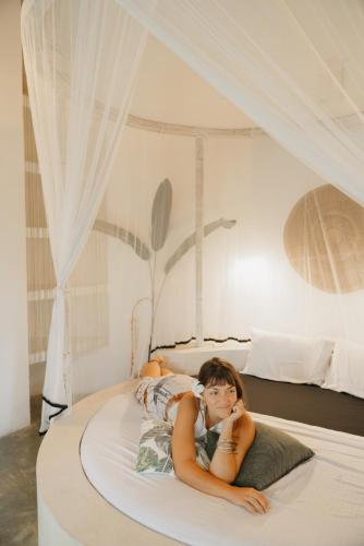 a woman laying on a bed in a bedroom at Kirinuga ECO Boutique Retreat in Tangalle