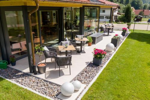 d'une terrasse avec des tables, des chaises et de la pelouse. dans l'établissement Landgasthaus Kurz Hotel & Restaurant am Feldberg - Schwarzwald, à Todtnau