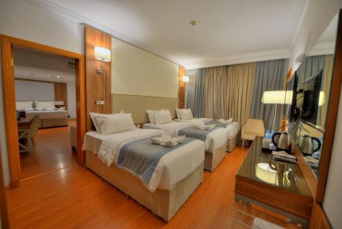 Al Ritz Al Madinah في المدينة المنورة: غرفه فندقيه سريرين وتلفزيون
