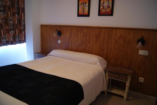 a hotel room with a bed and a table at Hostal Doña Isabel in Majadahonda