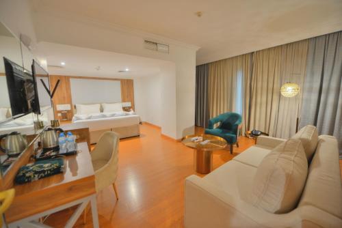 Habitación de hotel con cama y sala de estar. en Al Ritz Al Madinah, en Medina