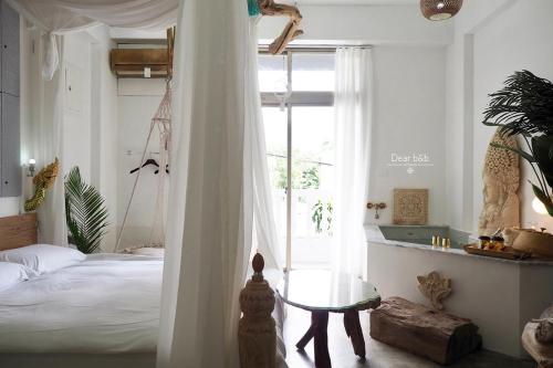 a bedroom with a bed and a table and a window at Fas BnB in Jiali