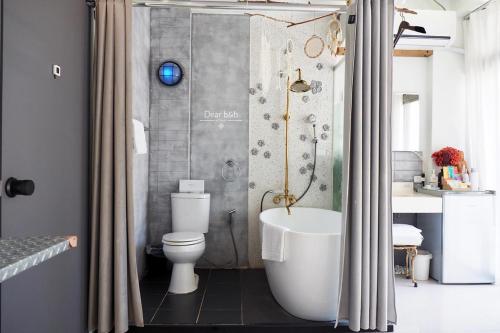 a bathroom with a toilet and a bath tub at Fas BnB in Jiali