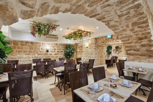 un restaurante con mesas y sillas y una pared de piedra en Hotel Berne Opera, en París