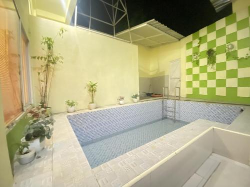 a bathroom with a swimming pool with a tub at Homestay RN near Taman Bambu Runcing Polewali Mitra RedDoorz in Matakali