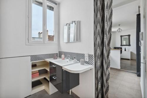 a bathroom with a sink and a mirror at Au coeur du triangle d'or de Versailles in Versailles