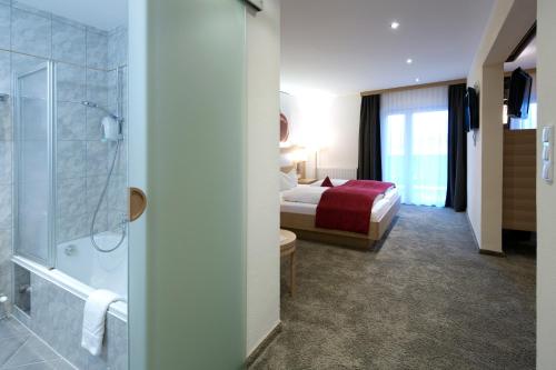 a hotel room with a bed and a shower at Geniesserhotel Alpin GmbH in Achenkirch