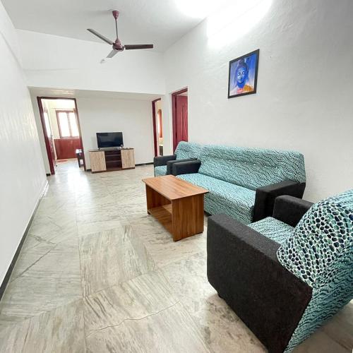 uma sala de estar com um sofá e uma mesa em WHITE HOUSE - 3BHK Elegant Apartment em Coimbatore