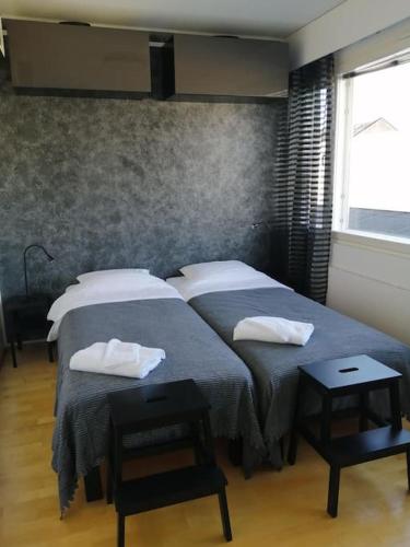 a bedroom with two beds with towels on them at Tyylikäs studio Helsingin sydämessä in Helsinki