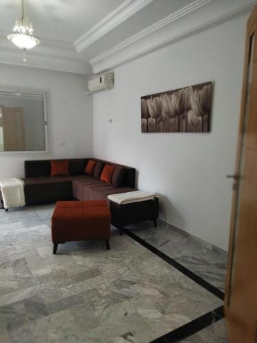 ein Wohnzimmer mit Sofa und Tisch in der Unterkunft Yasmine appartement A7 in Nabeul