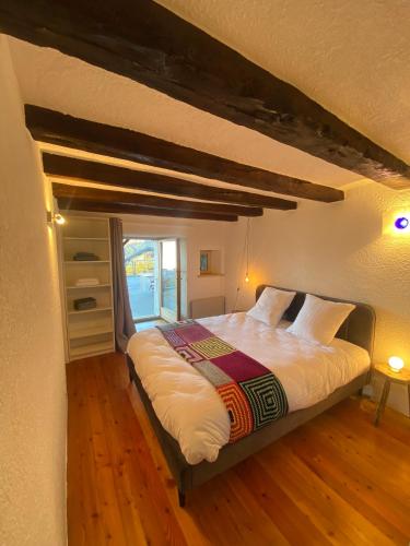 a bedroom with a large bed with a window at Chambre sur terrasse in Nendaz