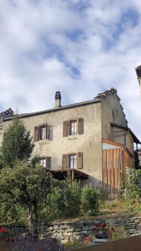 ein altes Gebäude mit verputzten Fenstern darauf in der Unterkunft Chambre sur terrasse in Nendaz