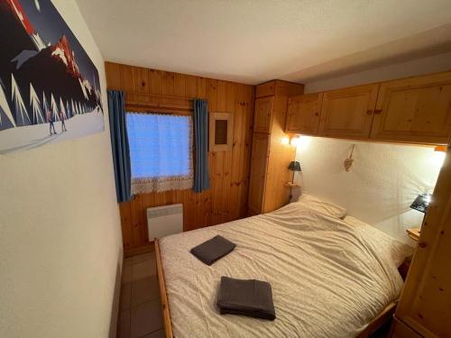 a small bedroom with a bed with a black hat on it at La forêt des Rennes in Villard-sur-Doron