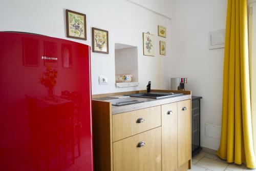 - une cuisine avec un évier et un mur rouge dans l'établissement Casina delle Rose - Scirocco, à Polignano a Mare