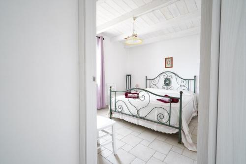 a white bedroom with a bed and a white floor at Casina delle Rose - Scirocco in Polignano a Mare